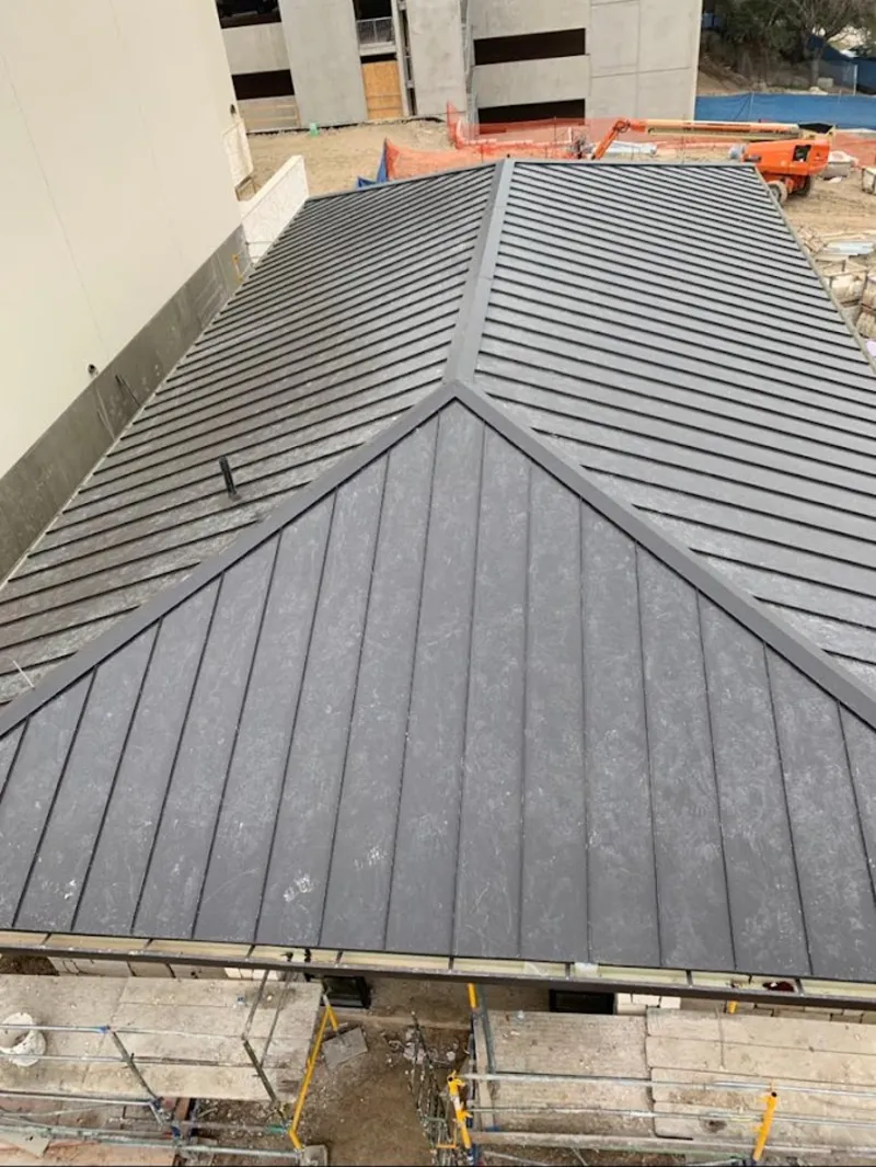 Commercial metal roof construction with crane equipment in Murrieta